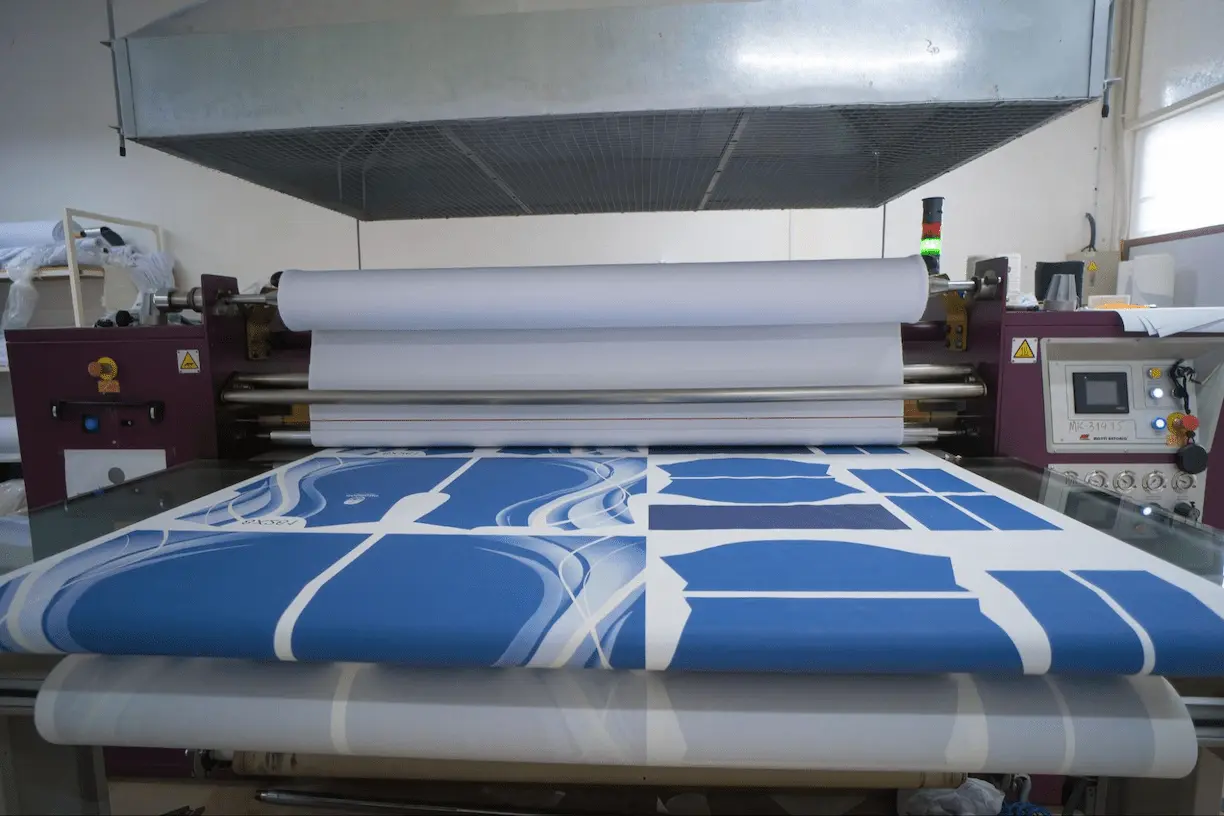 Detalhe de tecido estampado por sublimação digital destacando cores vivas e alta definição durante o processo de impressão.